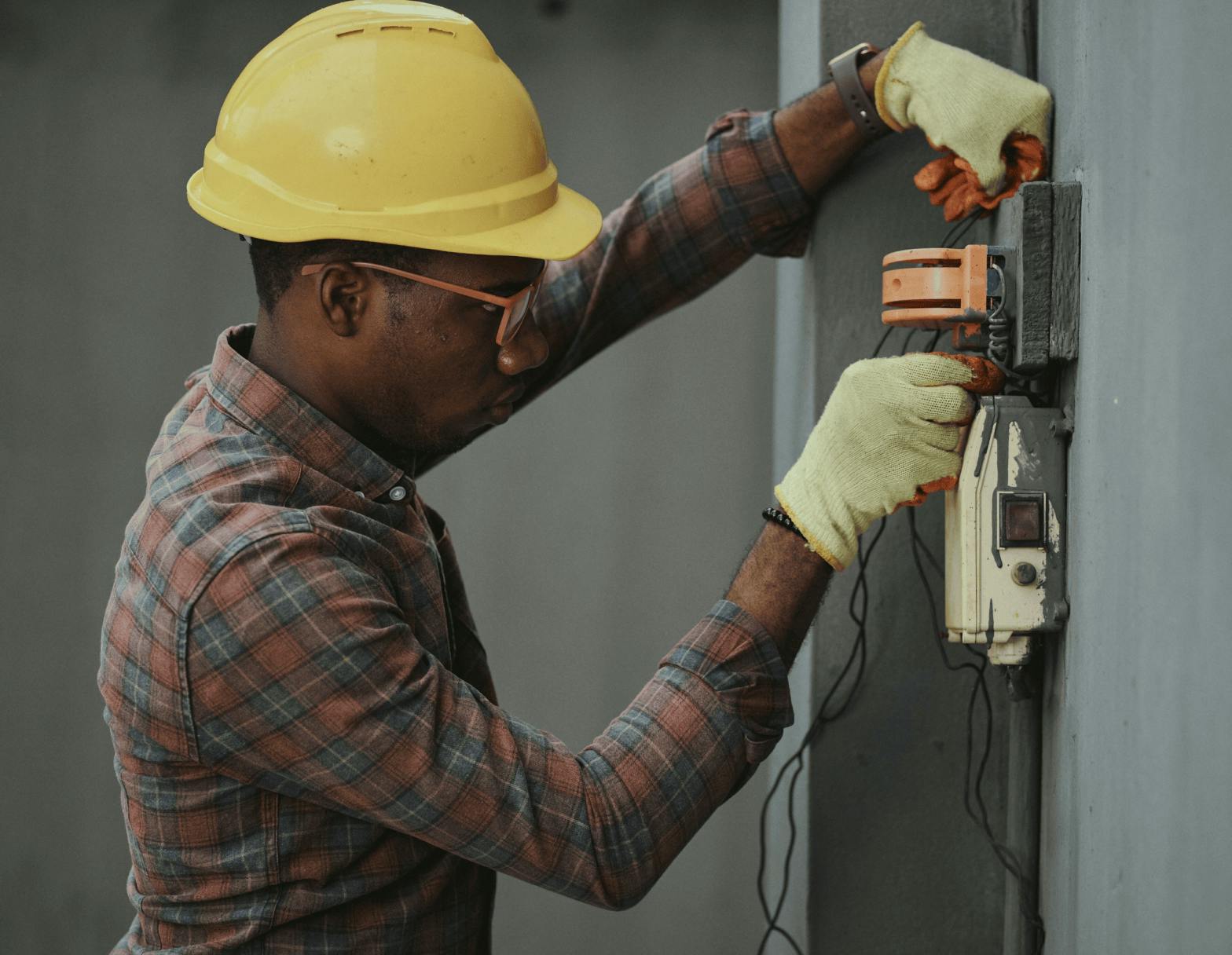 Man fixing a wall with a yellow helmet 