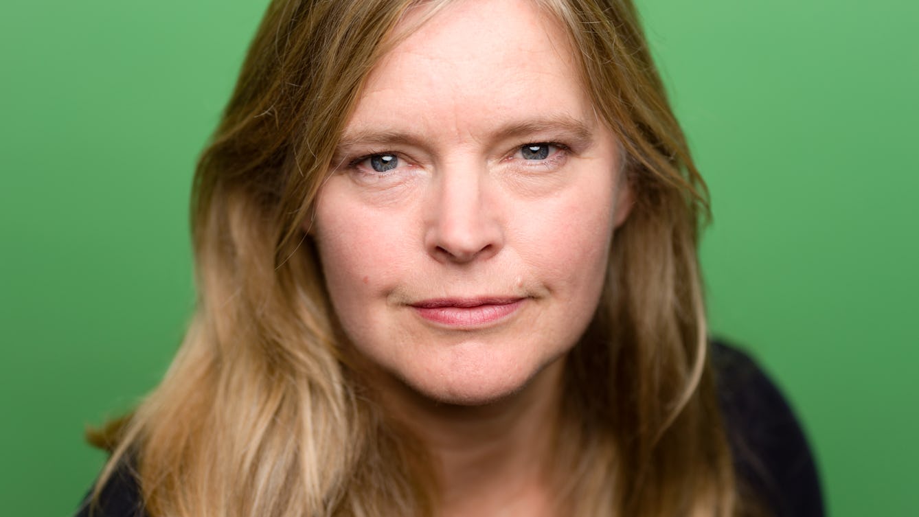 Head and shoulders photographic portrait of Katharine Dowson on a green background.