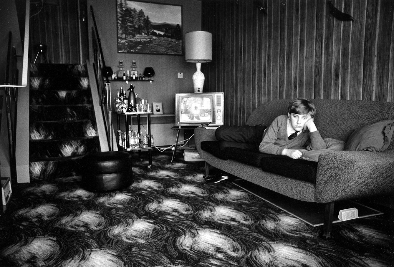 Photo of schoolboy in his living room in Deptford, London. By Tony Ray-Jones