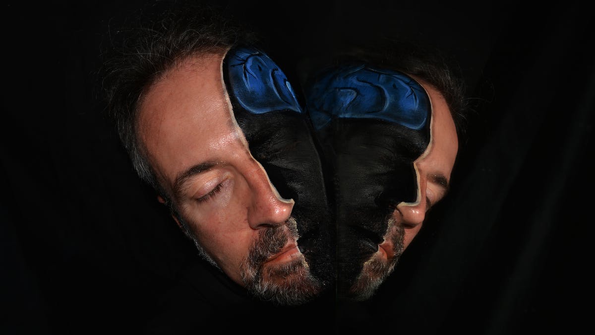 Art photograph using make-up to show the brain inside a man’s head, as thought the head had been split in two.
