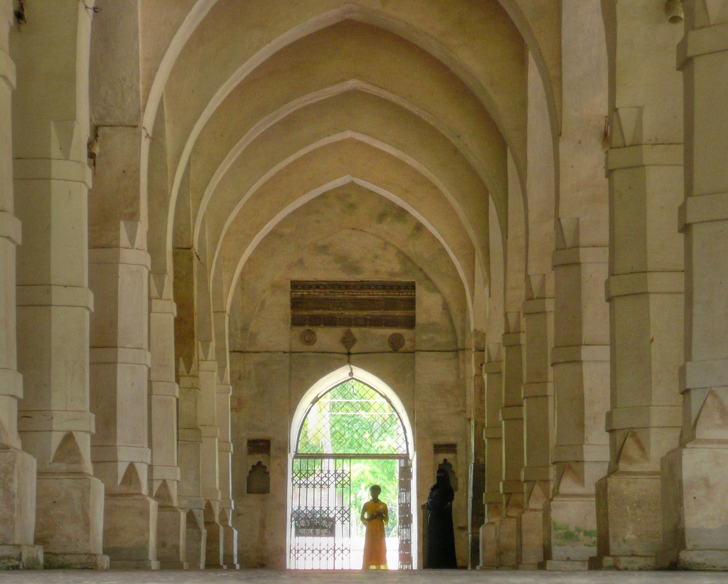 Shait Gumbad Masque in Bangladesh. 77 Domes. The two figures are a woman and her daughter who are standing next to a small women's waiting room near the entrance.