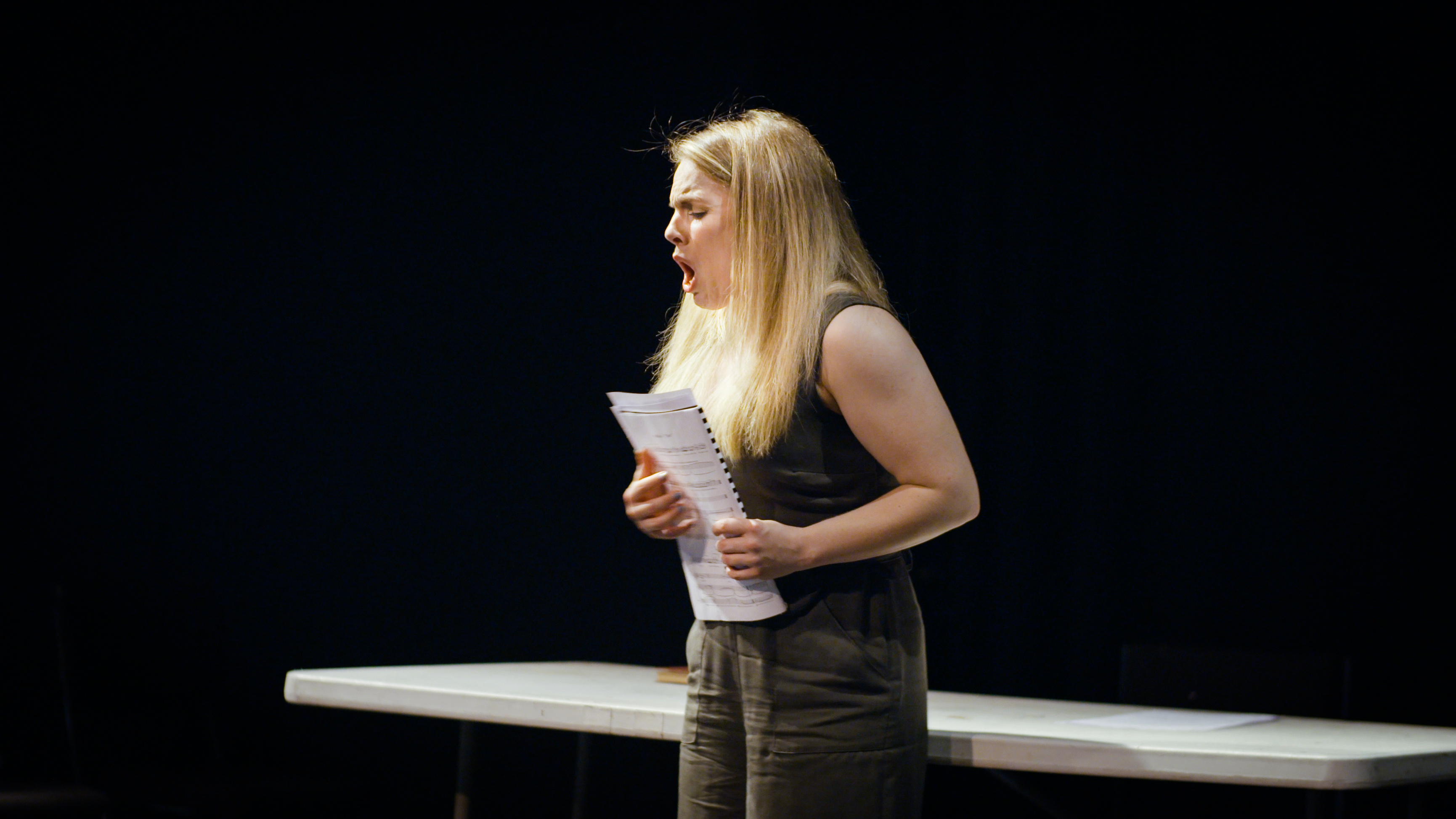 Photograph of soprano Alexa Mason rehearsing for Dear Marie Stopes in mid song, holding sheet music.