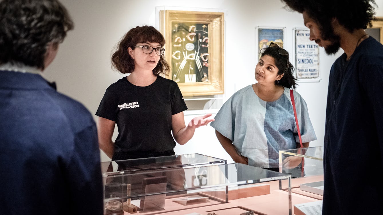 Photograph of a Visitor Experience Assistant conducting a tour of an exhibition at Wellcome Collection.