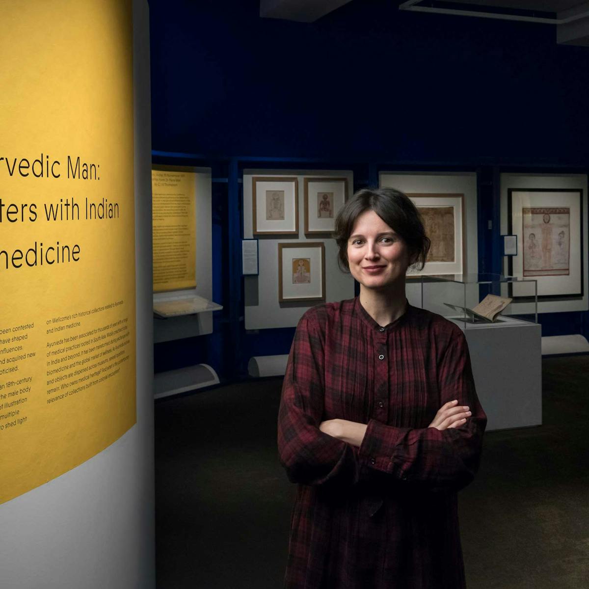 Curator Bárbara Rodriguez Muñoz standing at the entrance of the Ayurvedic Man exhibition