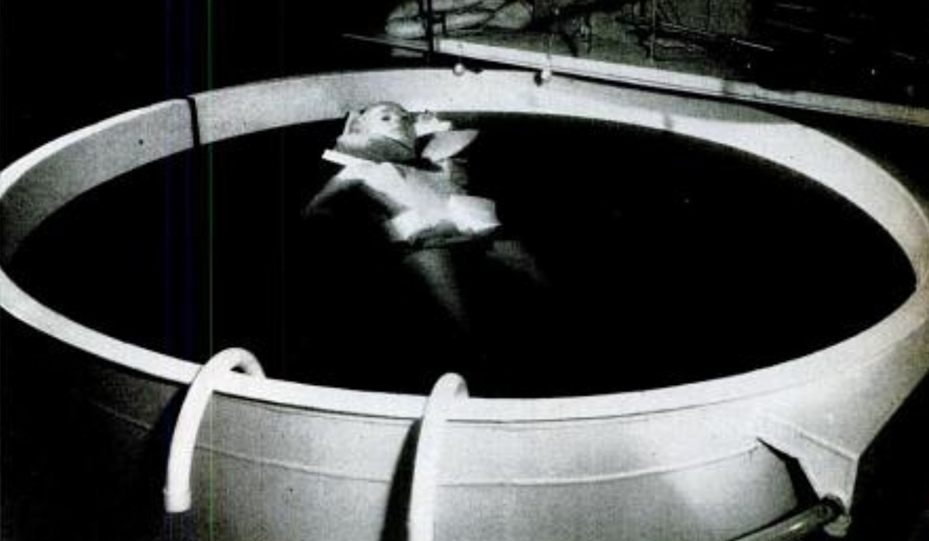 A woman floats in a tank of water on her back.