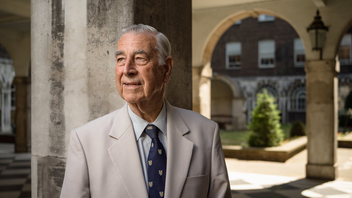 Photographic portrait of a man standing in the colonnades at Guys Hospital, London.