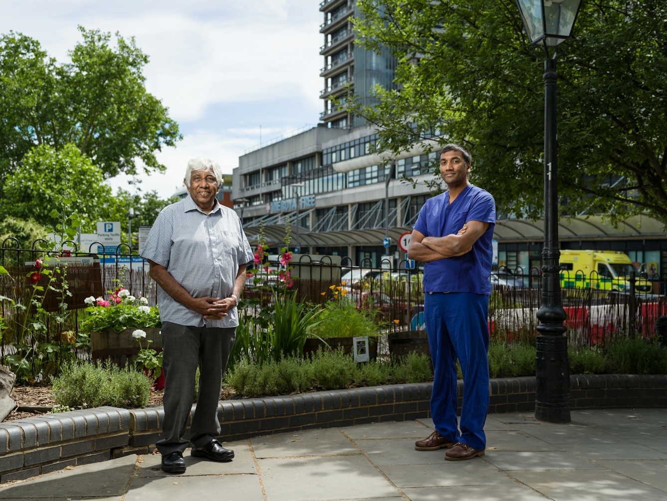 Photographic full length portrait of Oswald and Bimbi Fernando, transplant surgeons, outside the Royal Free Hospital.