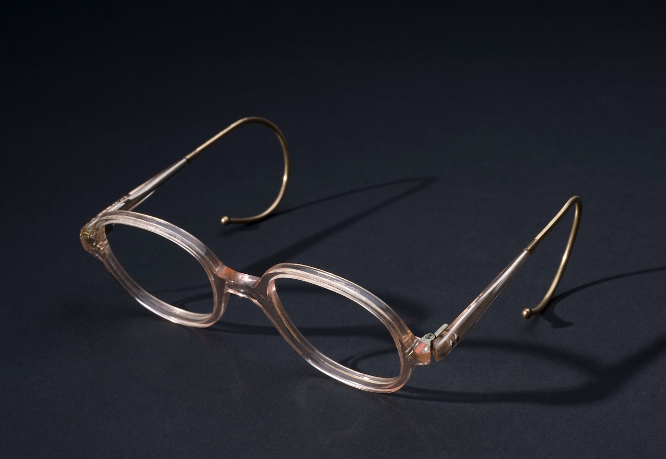 Glasses with pink plastic frames on a black background.