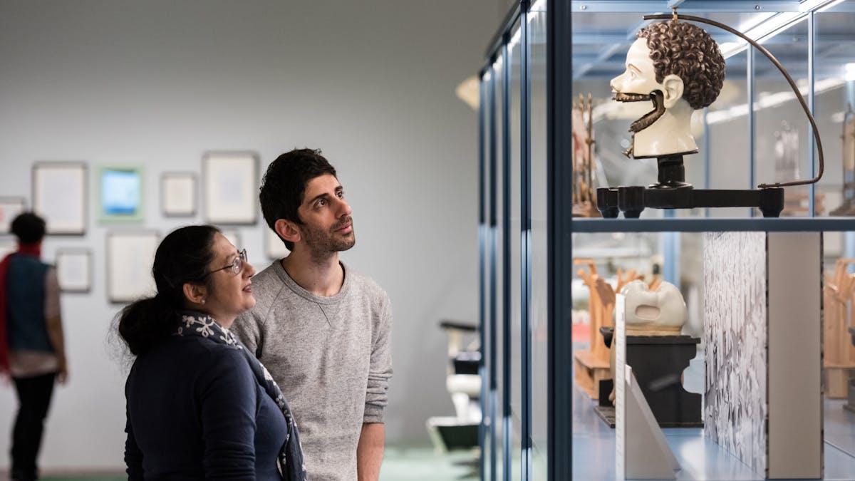 Photograph of a man and a woman looking at an exhibit in the Teeth exhibition at Wellcome Collection.