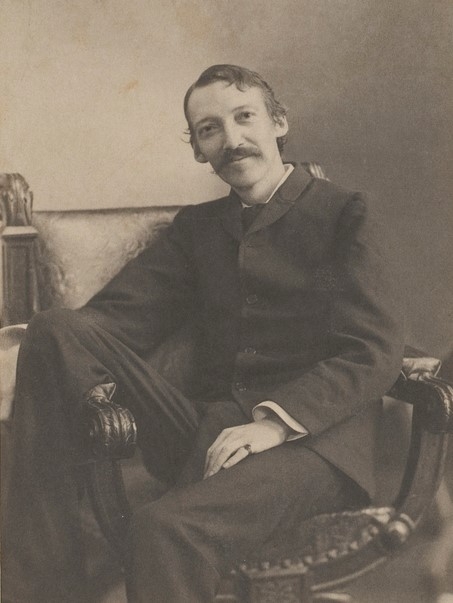 Black and white photographic portrait of Robert Louis Stevenson sitting in an armchair.