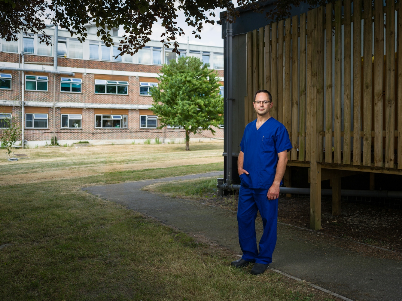 Photographic full length portrait of Ben Silverman, consultant anaesthetist, outside Harefield Hospital, Uxbridge.