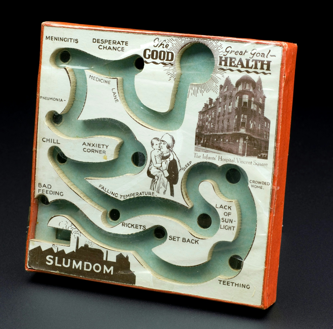 Board with a track in it and various holes for a small ball to fall into. The track begins at Slumdon and ends and "The Great Goal - Good Health".
