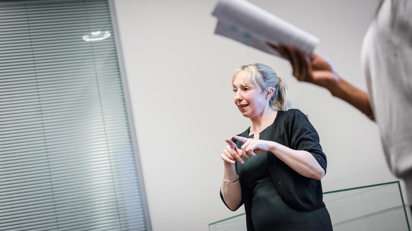 Photograph of a British sign language interpreter translating a talk at the Wellcome Collection Library.