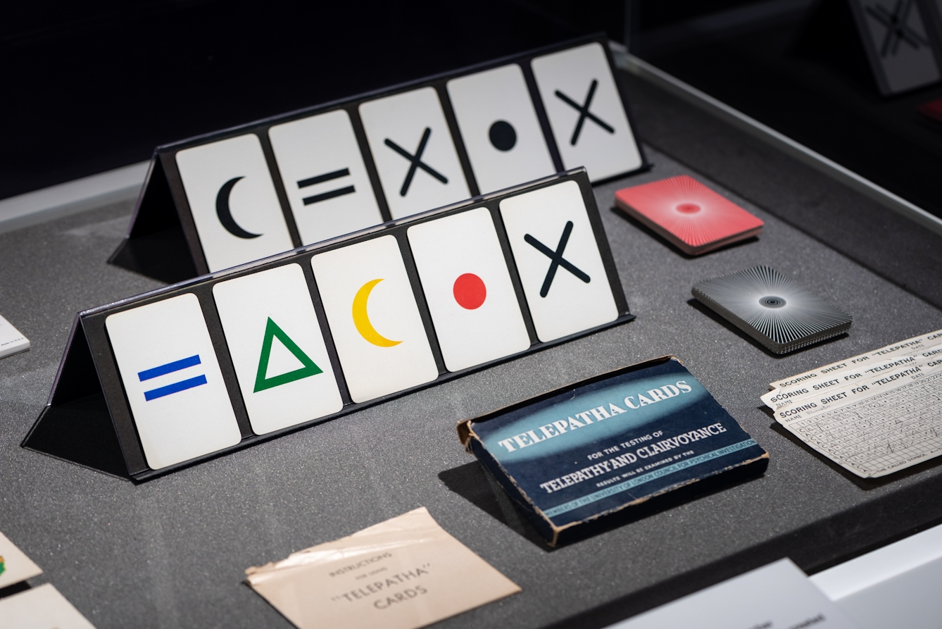 Photograph of a set of telepathy cards which have symbols printed on them, as part of the Smoke and Mirrors exhibition at Wellcome Collection.
