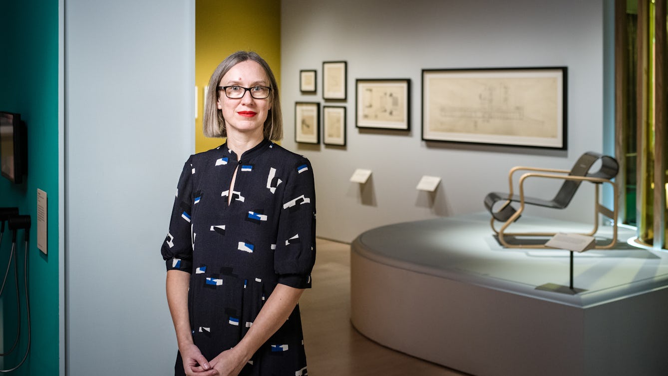 Photograph of Emily Sargent, curator of the exhibition Living with Buildings, standing in the gallery space.