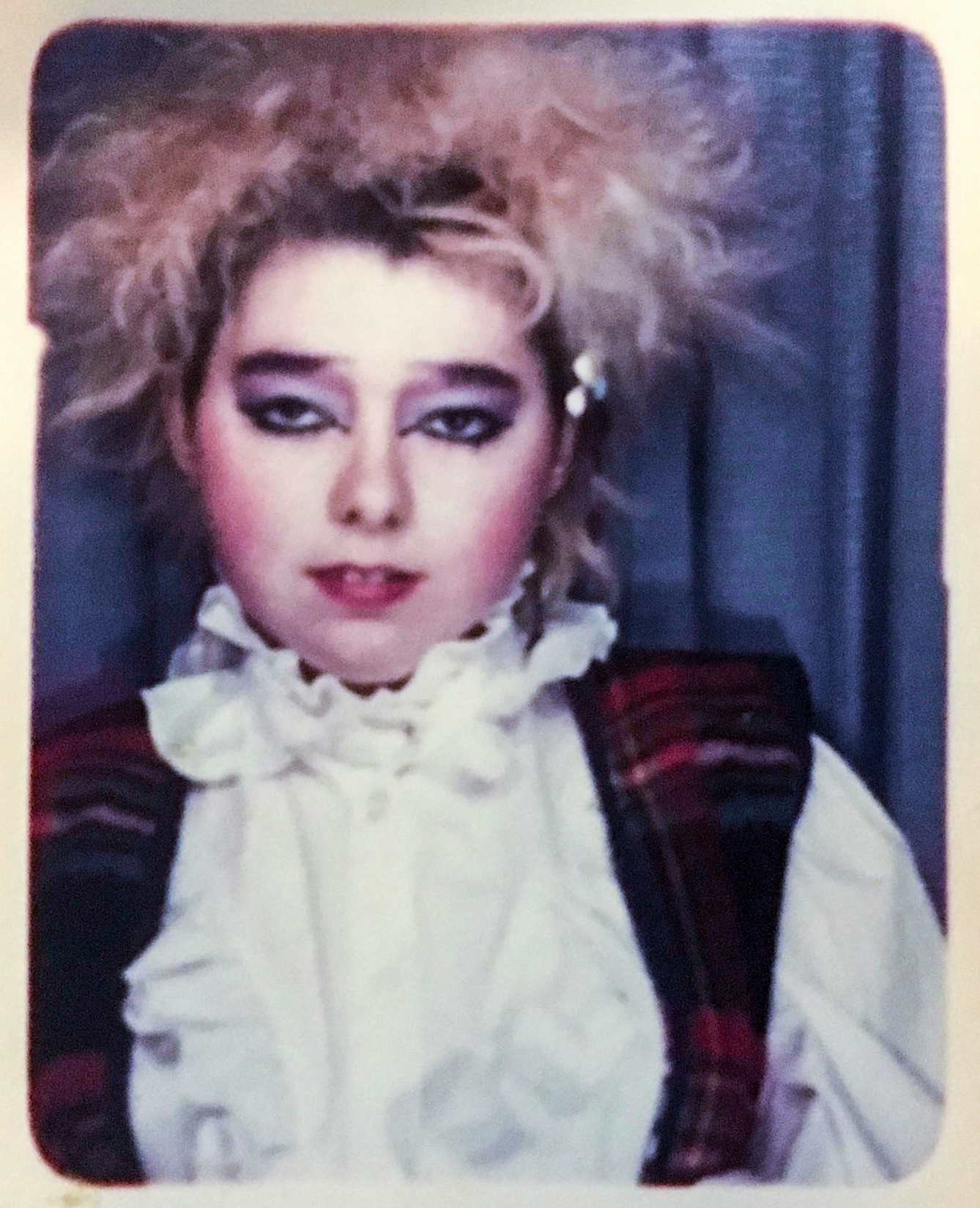 Photograph of a polaroid showing a young woman dressed in clothes from the punk era.