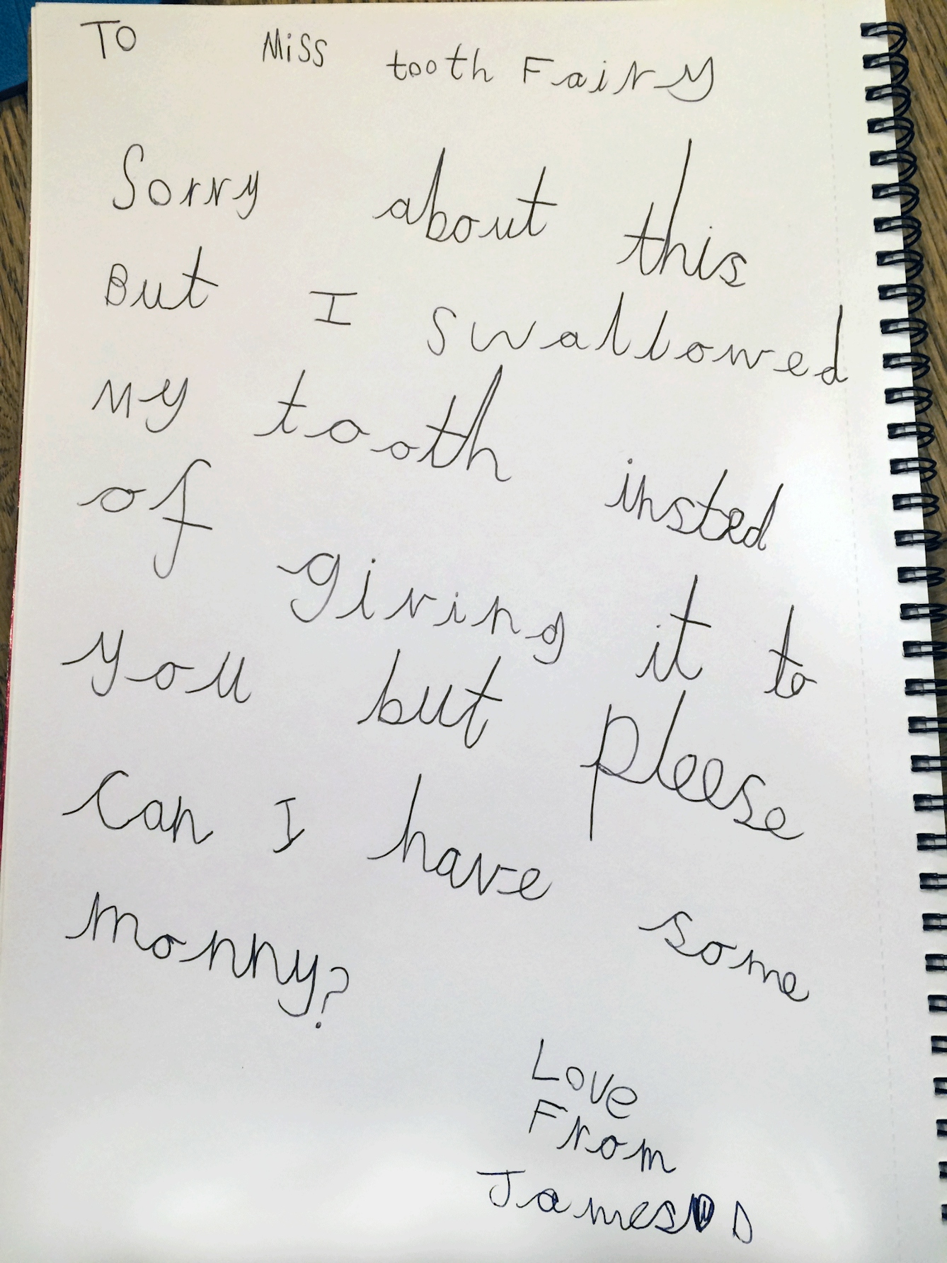 Letter written on white paper in a spiral-bound notebook. Reads: To Miss Tooth Fairy, sorry about this, but I swallowed my tooth instead of giving it to you, but please can I have some money? Love from James D