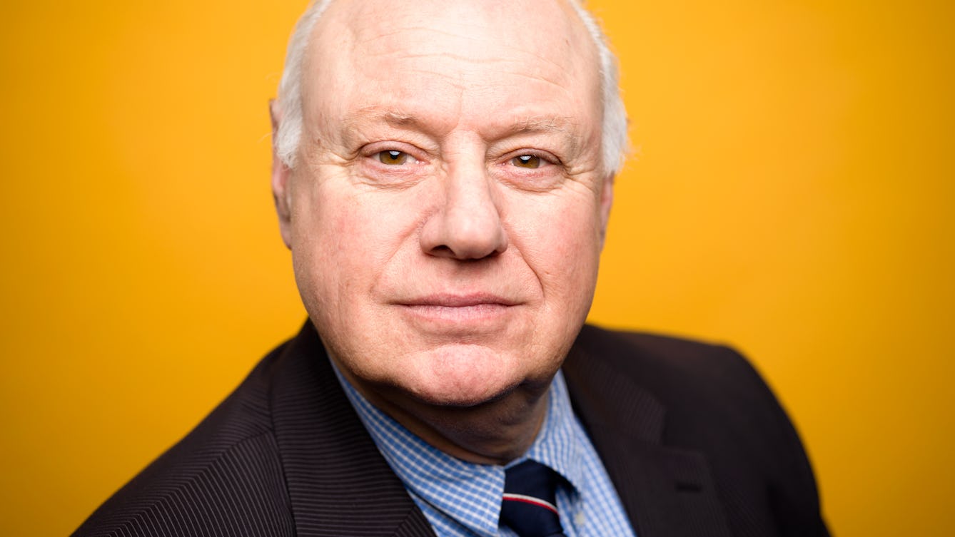 Photographic head and shoulders portrait of Alan D Murray against a colourful background.