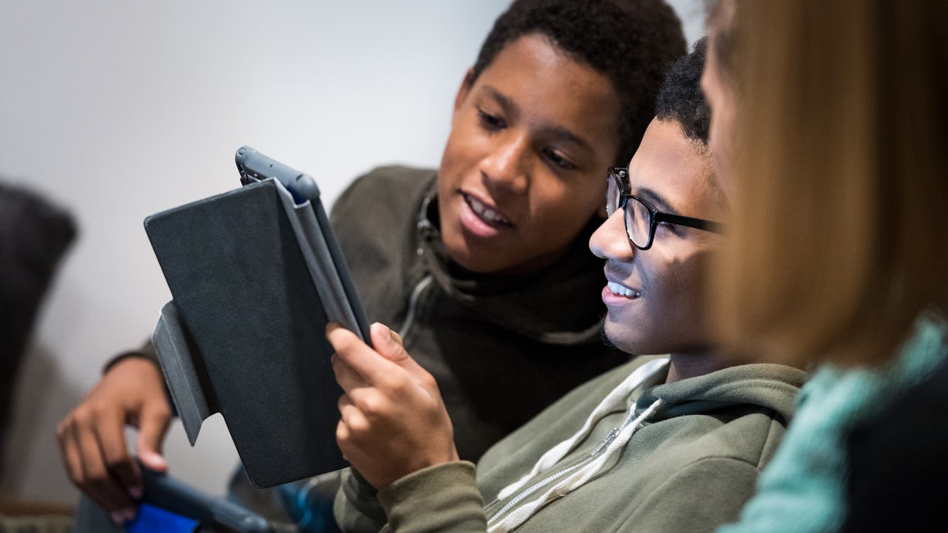 Photograph of two young men undertaking an activity on a tablet device.