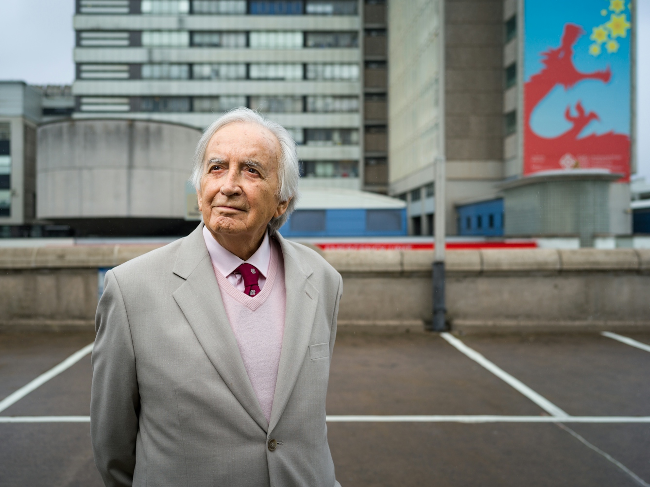 Photographic portrait of Morgan David Enoch standing in front of University Hospital of Wales.