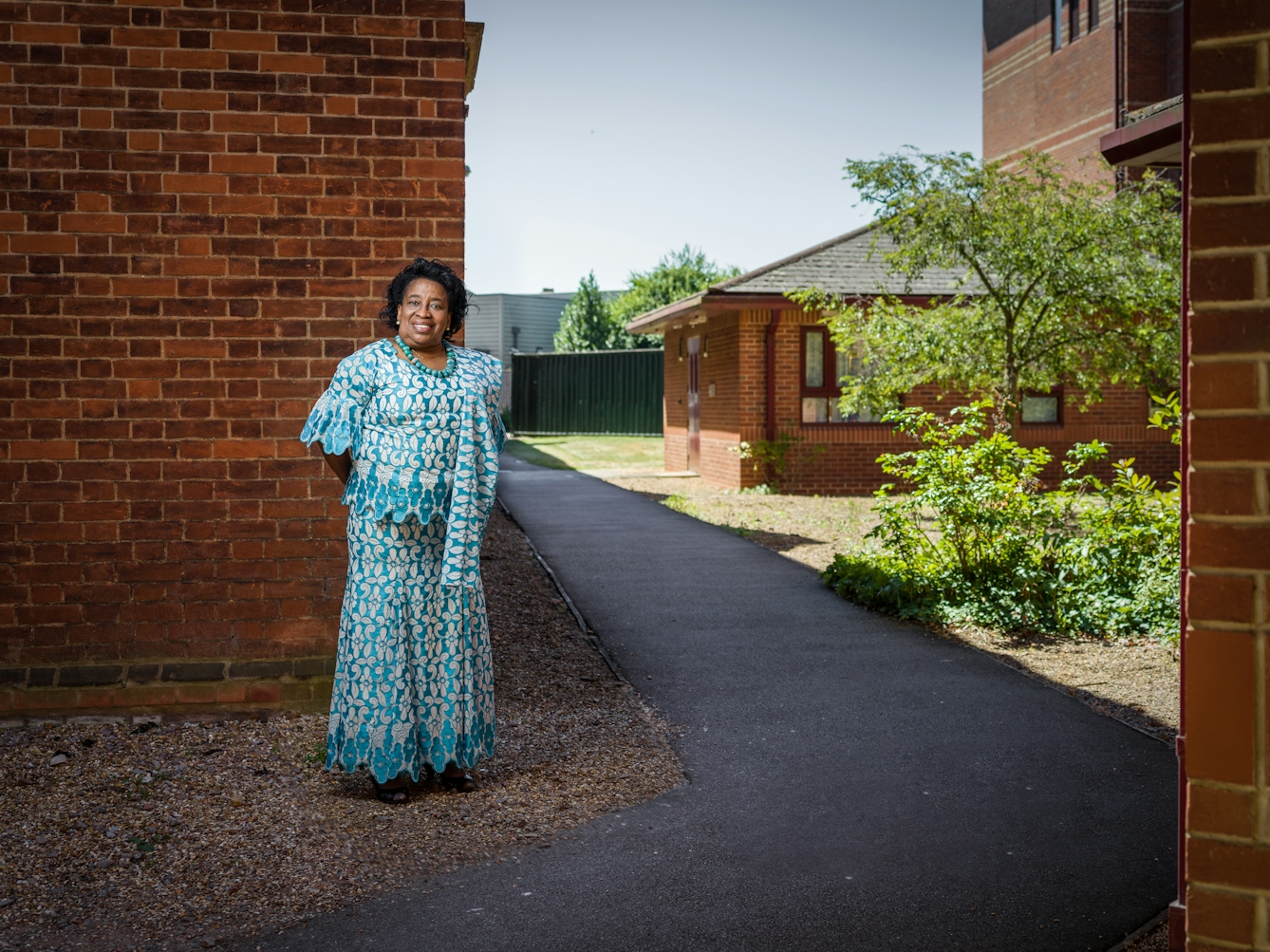 Photographic full length portrait of Cynthia Stuart, midwife, outside Bedford Hospital.