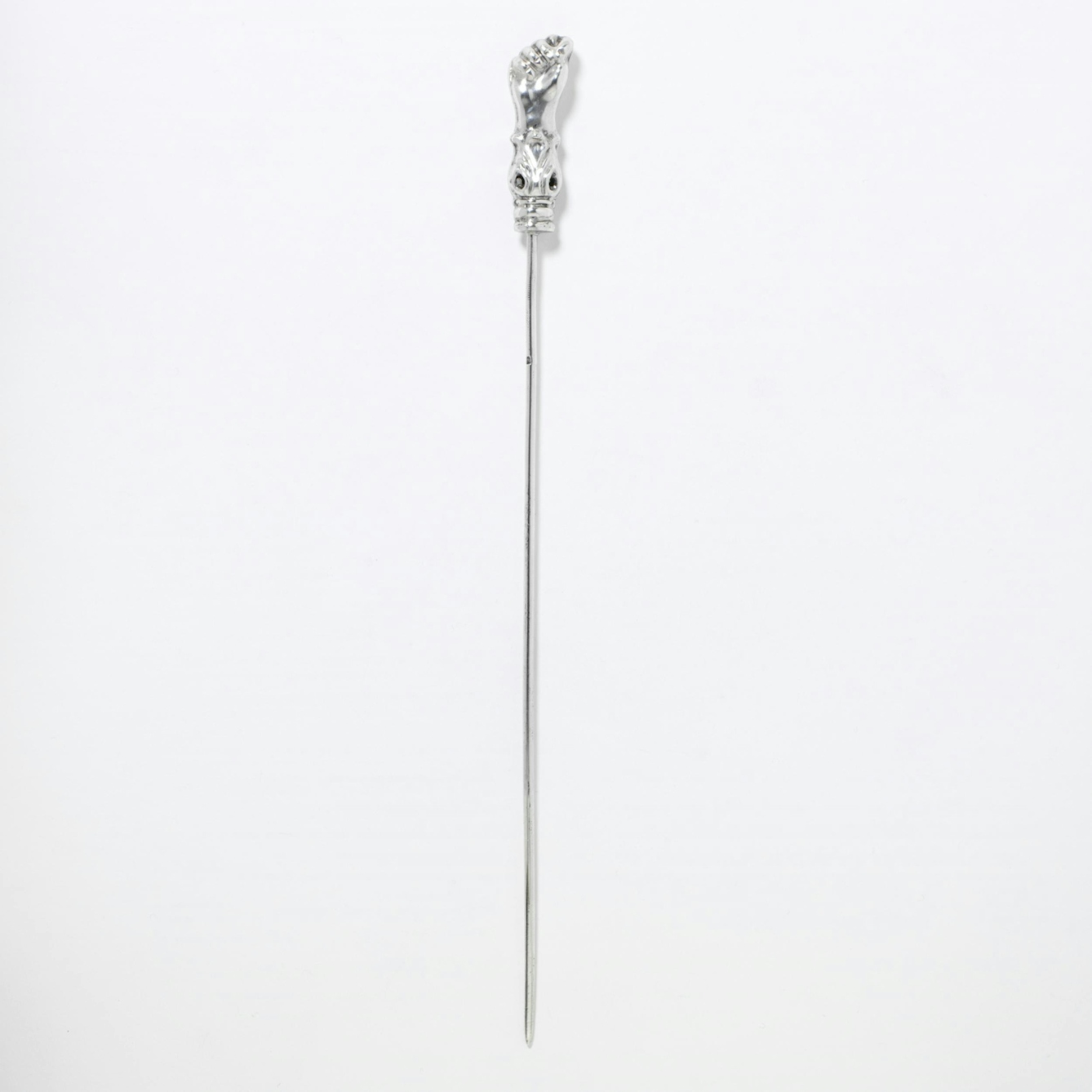 A polished silver pin with a long stem and a small clenched fist at the top.