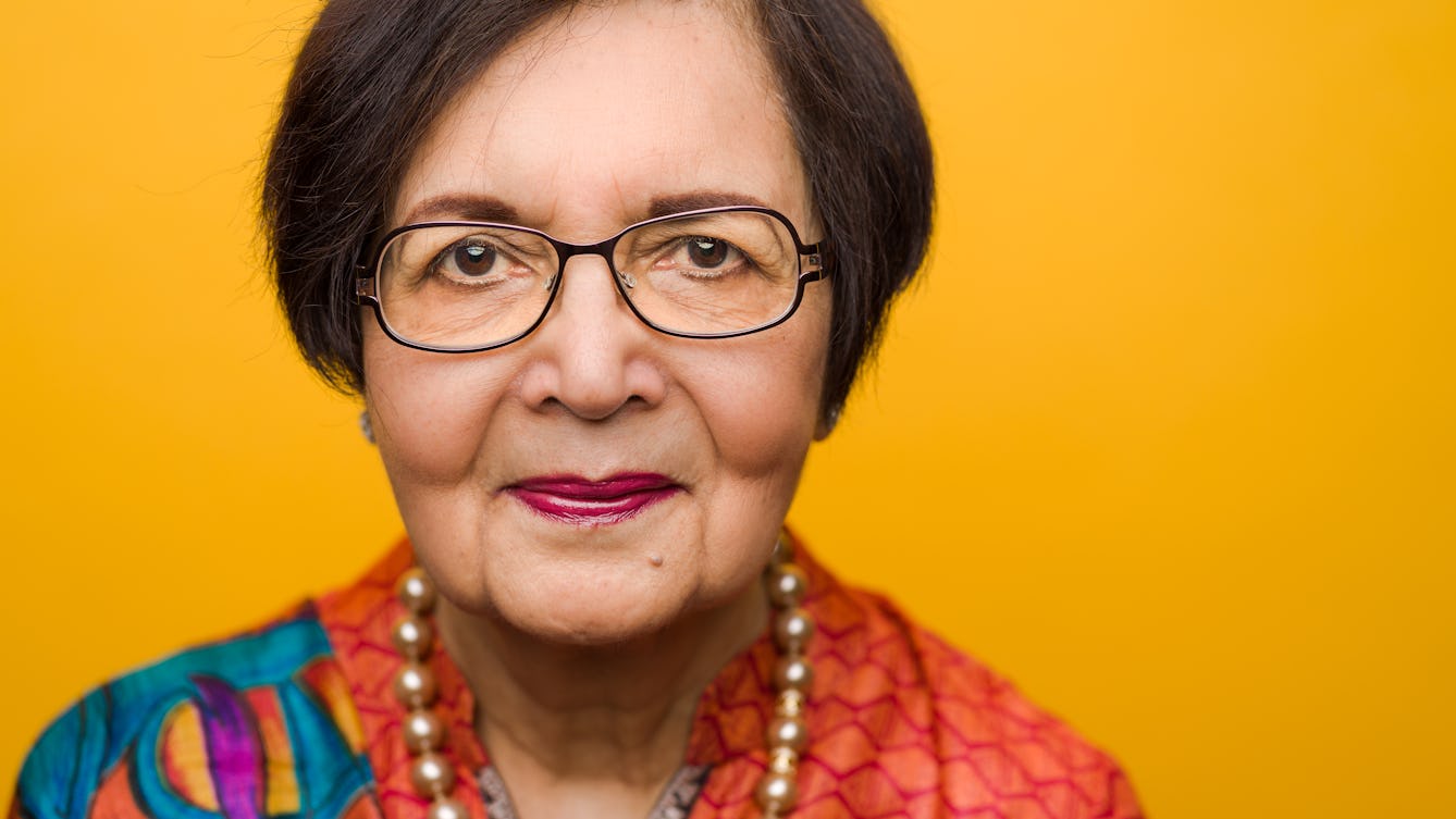 Close-up photographic portrait of Vinod Saggar's face and shoulders, against a yellow background.