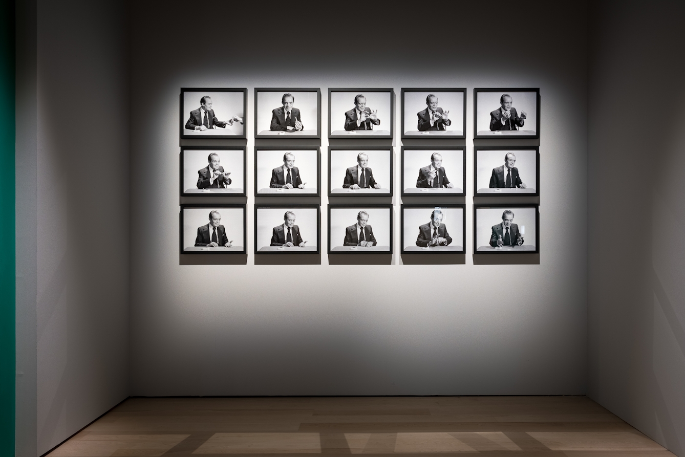 Photograph of a series of 15 framed black and white photographs which show a man performing 'the cigarette trick', as part of the Smoke and Mirrors exhibition at Wellcome Collection.