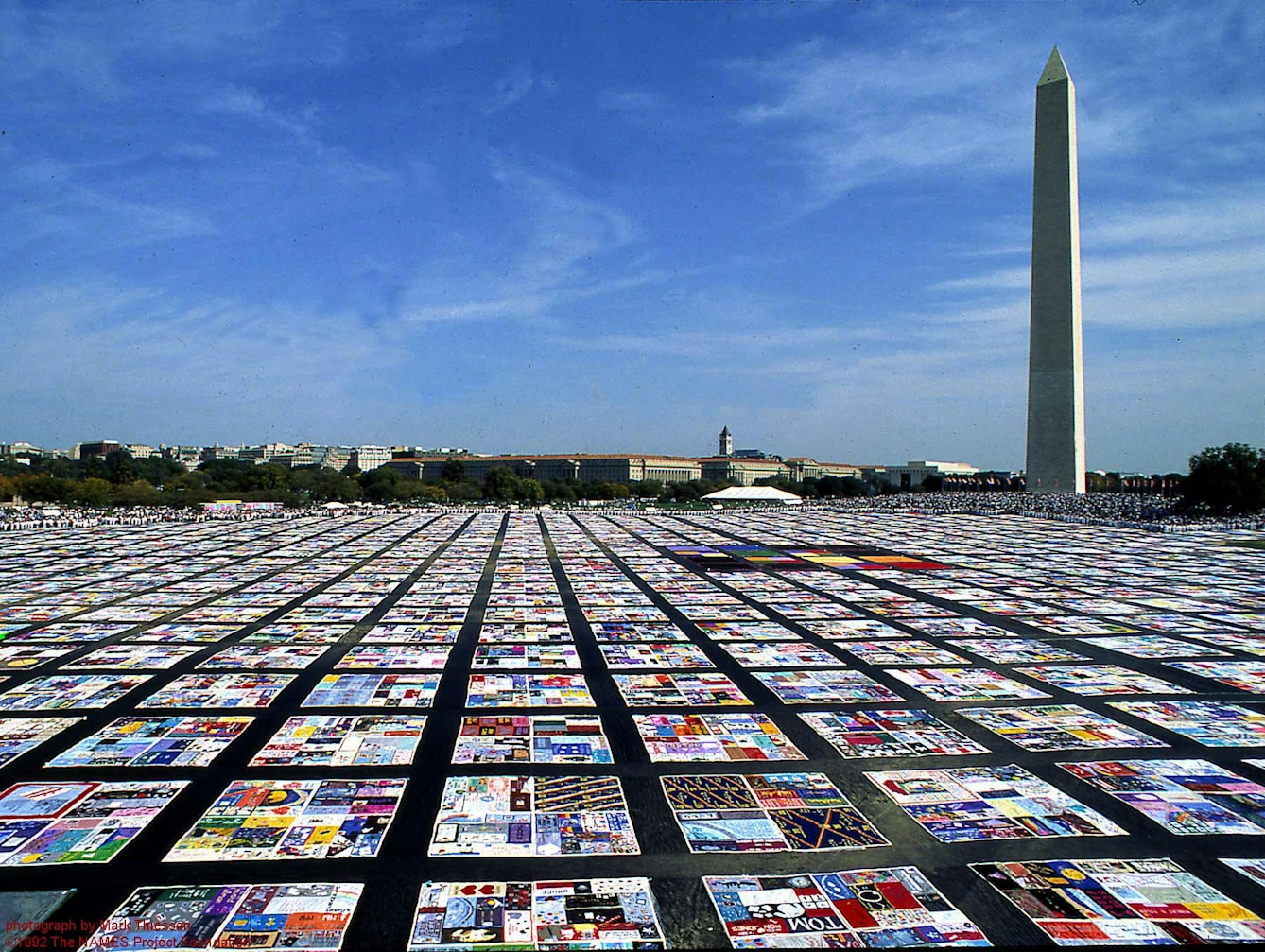 Picture of the AIDS quilt in front of the Washington Monument on a sunny day