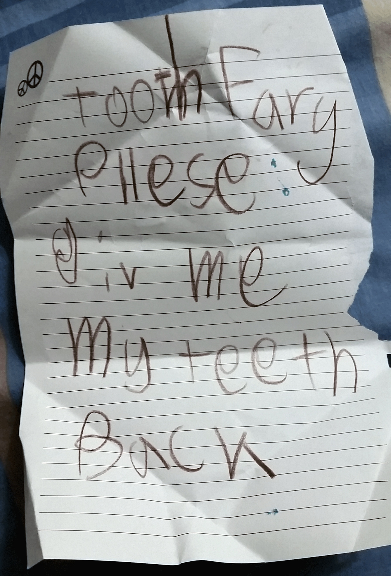Note on lined paper written in large black crayon letters. Reads: Tooth Fairy, please give me my teeth back.