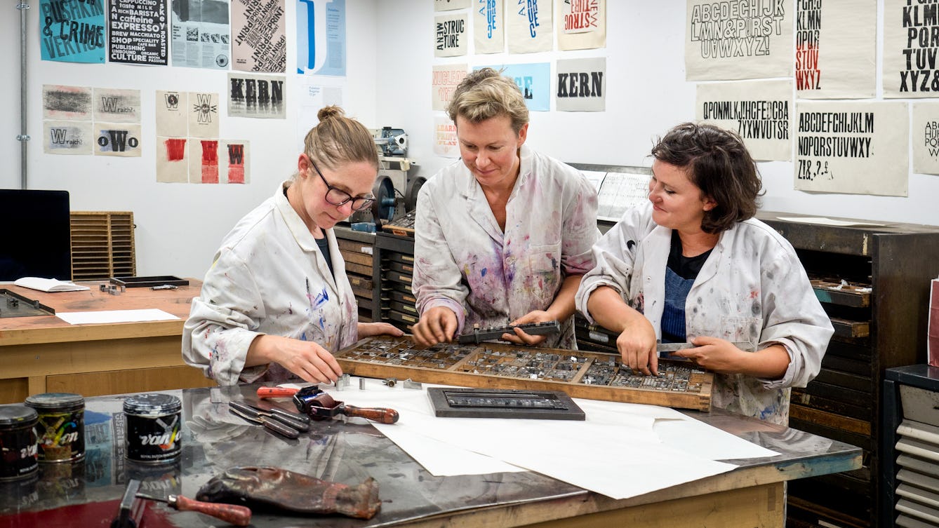 Photograph of Clare Qualmann, Amy Sharrocks and Madeleine Hodge working in the printmaking studio at London Metropolitan University.