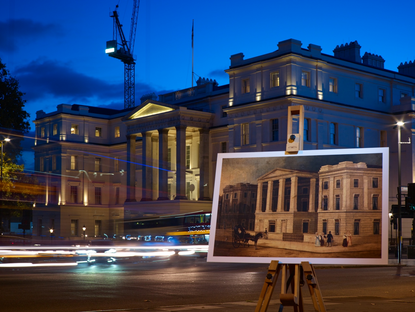 Photograph of the former St George’s Hospital with an historical image of the hospital displayed in front of it on a wooden artist's easel.