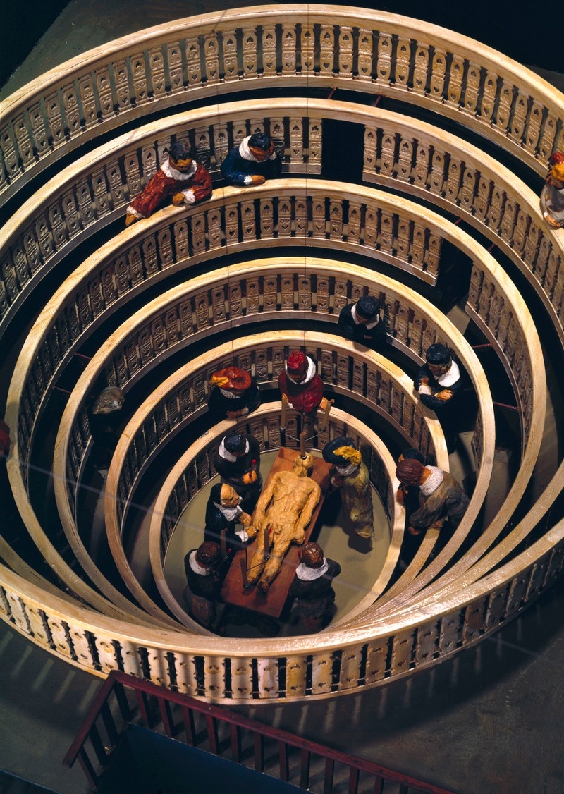 Image of round anatomy theatre model with people around a body