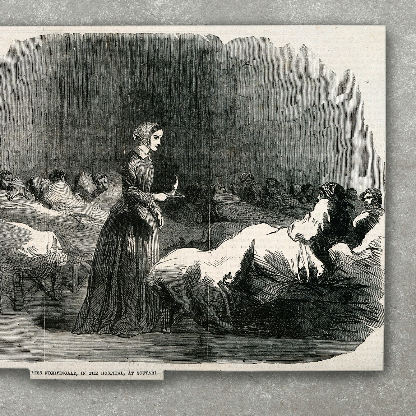 A black and white wood engraving of Florence Nightingale, surrounded by patients in hospital beds, photographed on a concrete textured background.