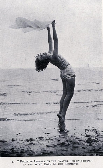 Woman exercising on a beach with a scarf in her raised arms