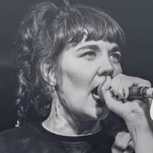 Black and white photograph of Jenny Moore singing into a microphone.