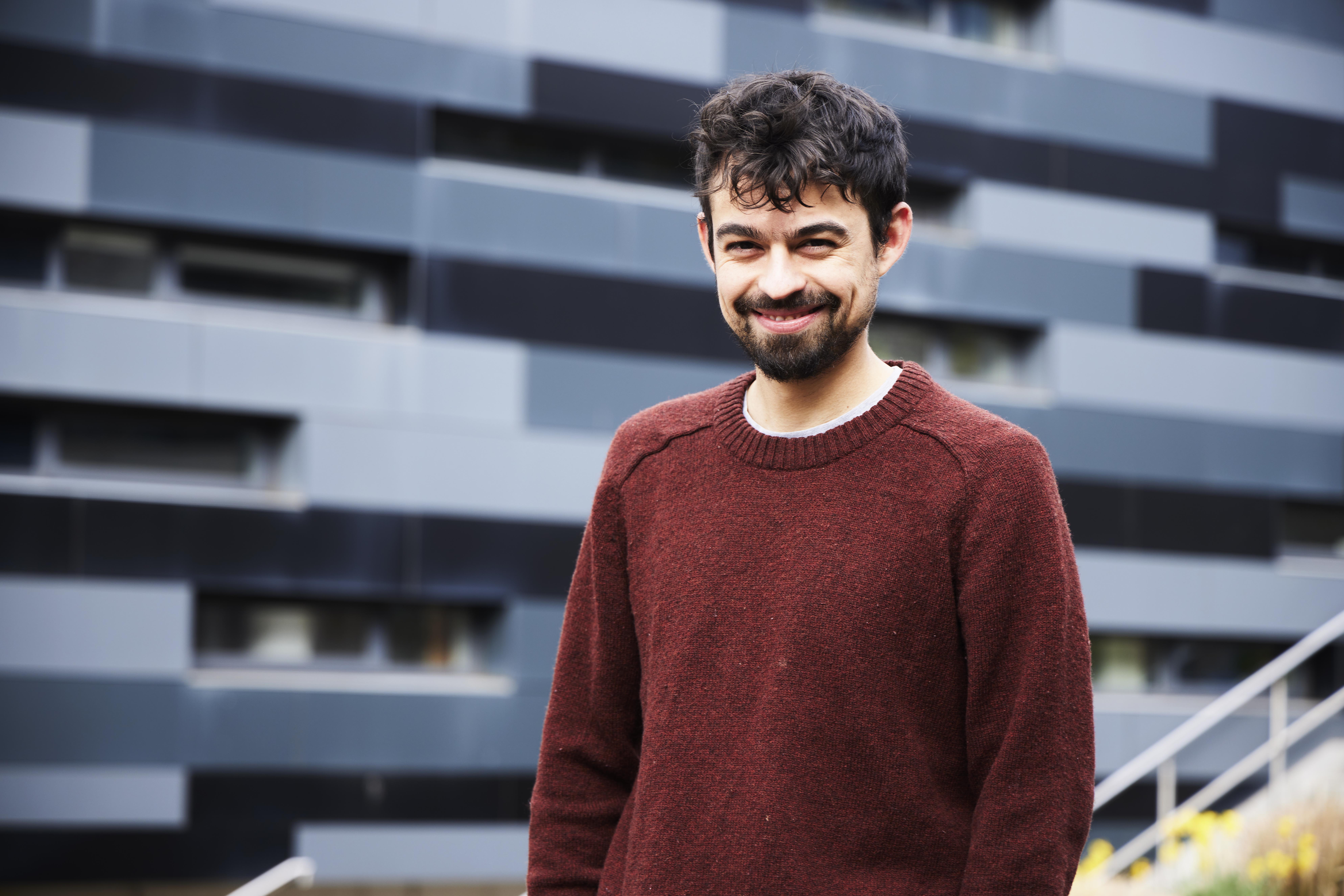 A photo of Felipe Martínez-Fernández smiling, wearing a red jumper