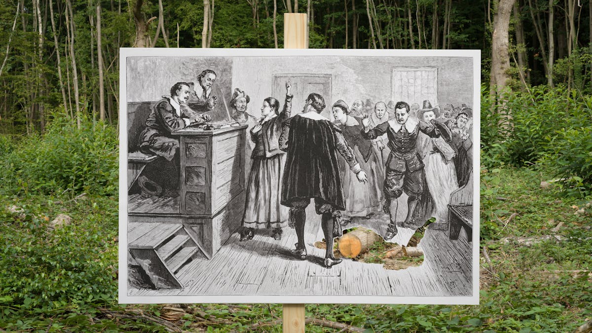 An etching of a courtroom photographed in front of a landscape featuring a forest in the background. The plaintiff in the courtroom is cut out and the landscape is shown through the aperture.