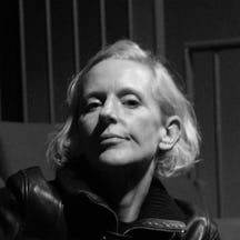 Black and white photograph of a woman with short blond hair looking straight at the camera.