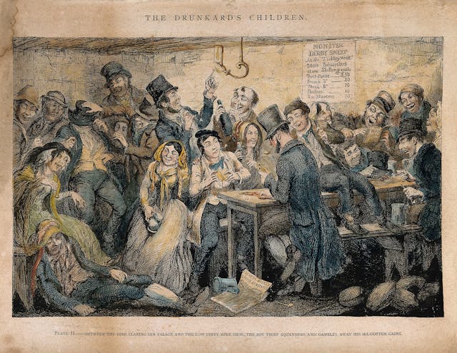 A colour illustration showing a busy interior scene of a drinking den. A group of men and women are crowded around a long table with bench seating. Some are laughing, some are slumped. Some of the people at the table are playing cards. A poster on the wall says 