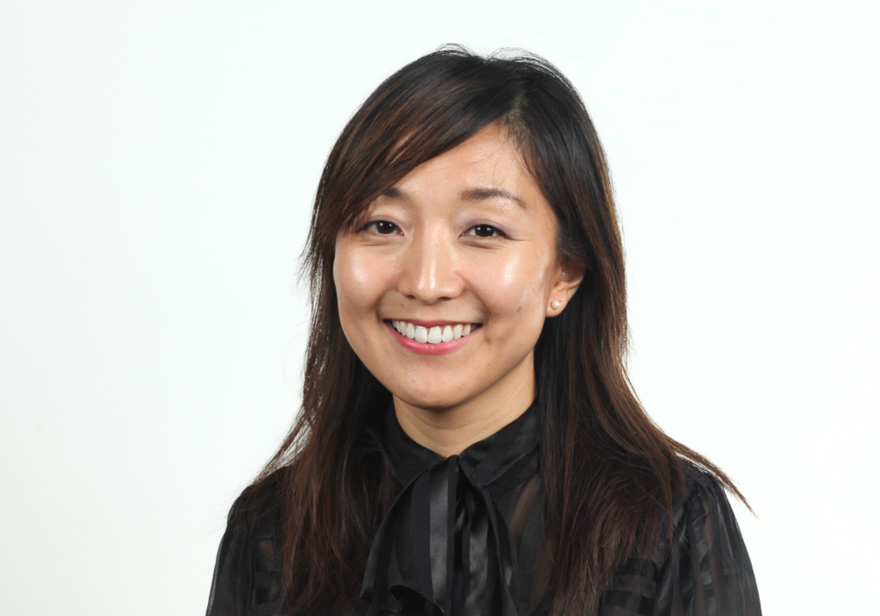 A head and shoulders photograph of a woman, smiling.