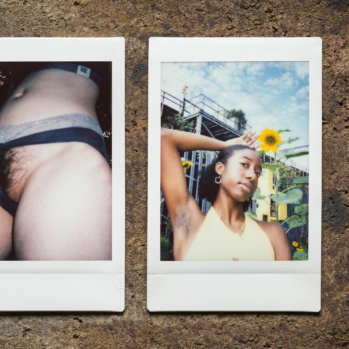 Photograph of three Instax Mini instant film prints in a line, resting on a textured brick surface. The print on the left shows a man wearing a black cropped vest standing against a graffitied wall with his right arm raised up behind his head to show his armpit hair. The print in the centre shows a closeup, flash lit image of a woman's groin and midriff. She is pulling aside her knickers to show her pubic hair. The print on the right shows a woman standing outside in front of a metal staircase. Behind her is also a tall sunflower. Her right arm is raised up behind her head to show her armpit hair.