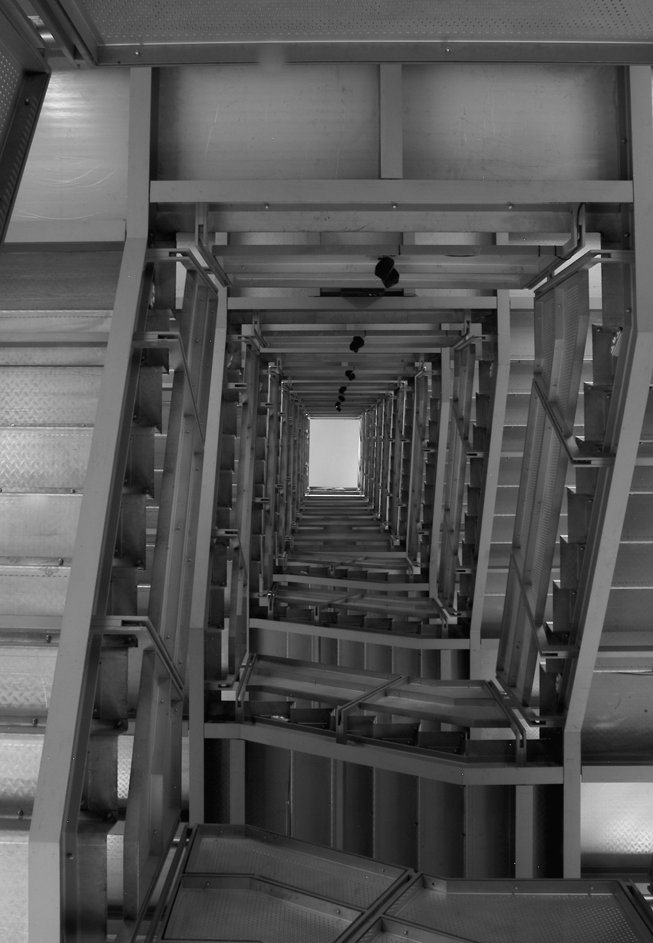 Photo shows the long distance to the ceiling when looking up from the bottom of a stairwell.