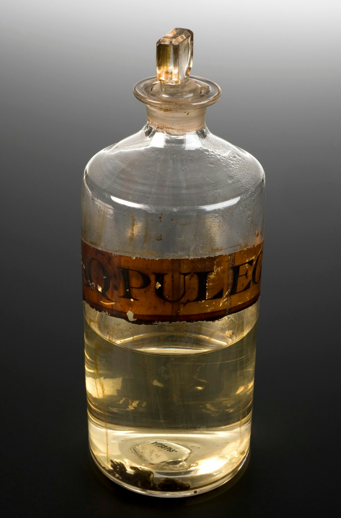 Photo of glass jar half-filled with gold coloured liquid