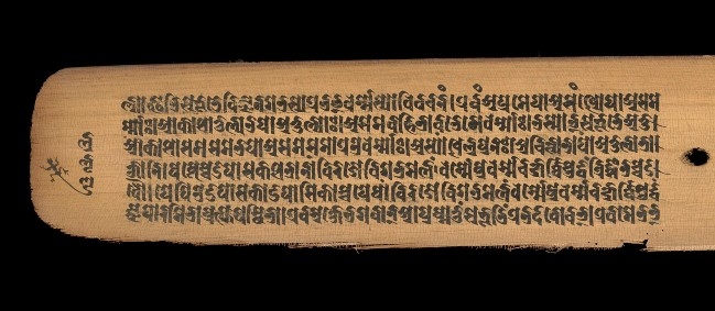 Detail from a palm leaf manuscript page showing text in sanskrit/bhujimol script. Heavy black text read horizontally on yellow palm leaf background