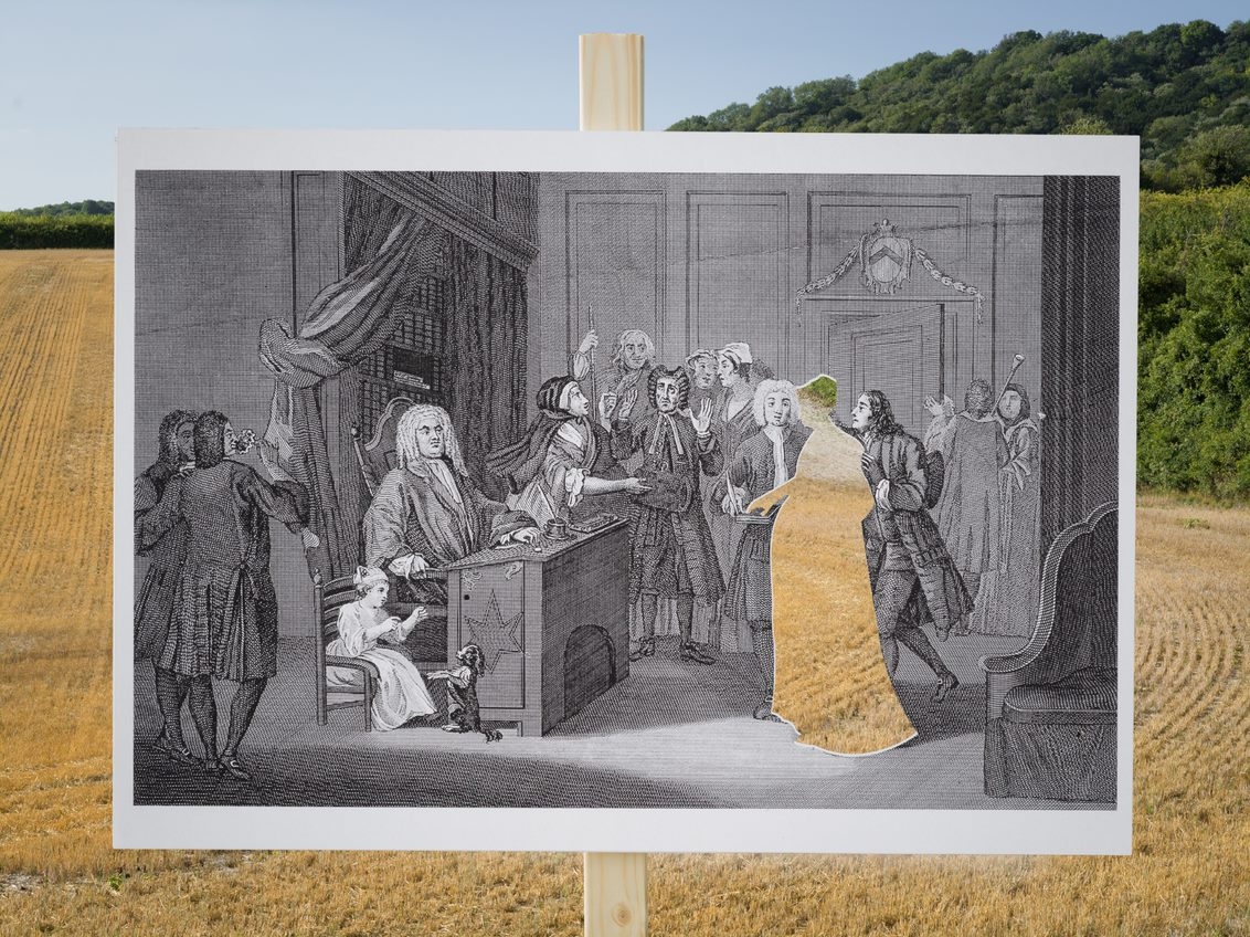 An etching of a courtroom photographed in front of a landscape featuring farmland in the background. The plaintiff in the courtroom is cut out and the landscape is shown through the aperture.