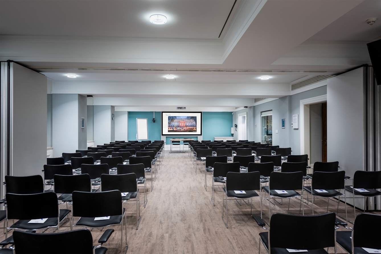 Photograph of the Franks and Steel room at the Wellcome Collection. 

Photograph shows a theatre space with chairs and a projector and screen set-up. 