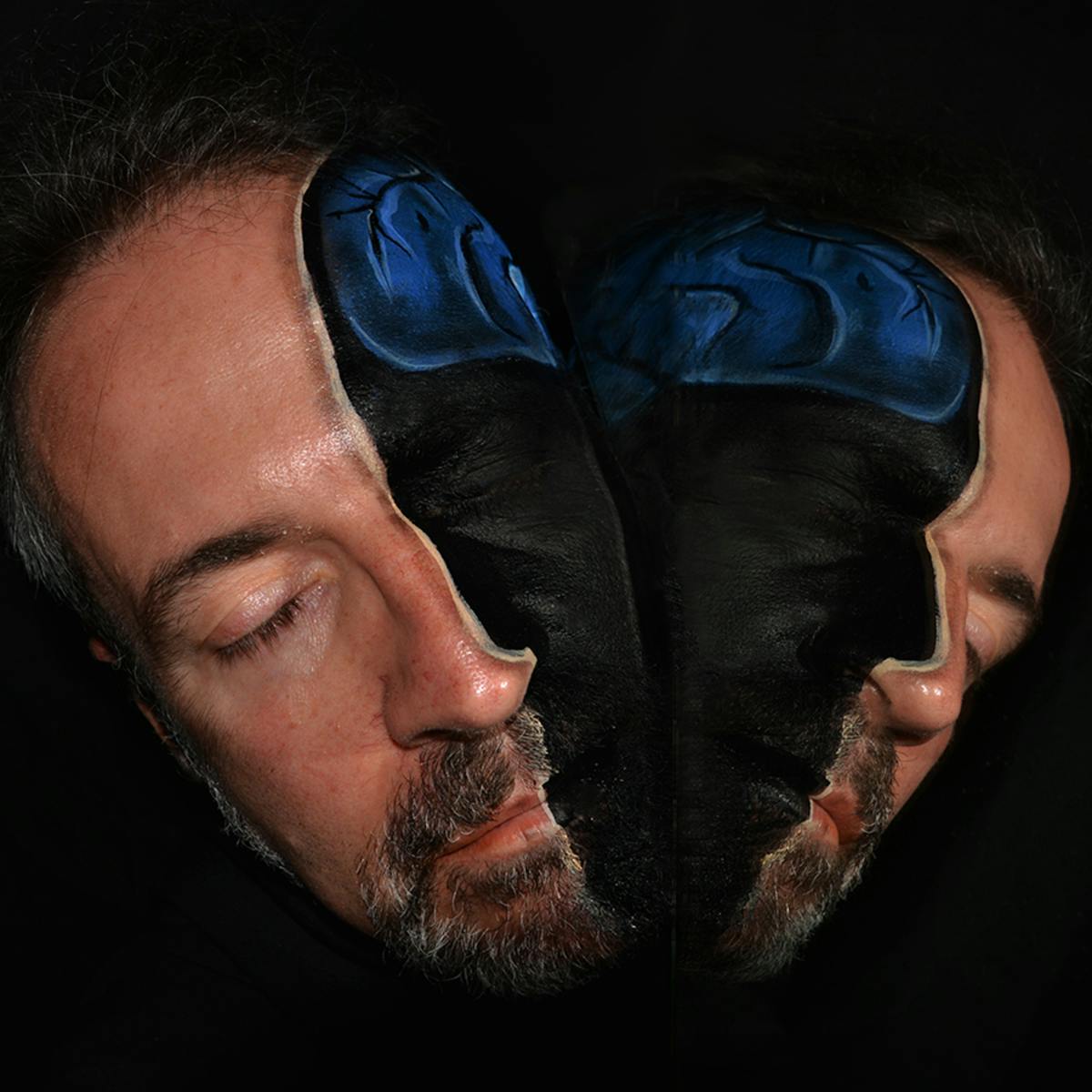 Art photograph using make-up to show the brain inside a man’s head, as thought the head had been split in two.