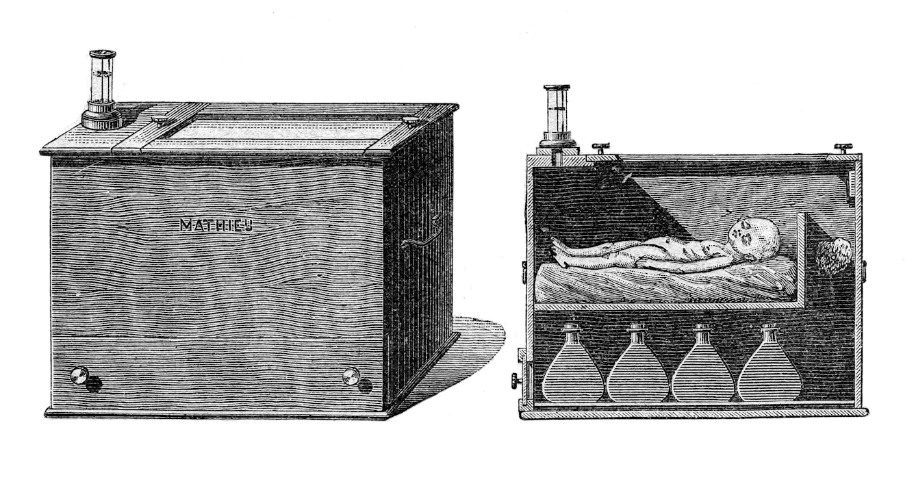 A black and white archive image showing an early incubator. There are two views of the machine: one is an exterior view, the other is cross section showing the interior, where a baby is visible inside. The baby is lying on a small bed, with four large flasks underneath.
