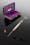 Metal syringe with a spare needle and (in background) a purple-velvet lined case.